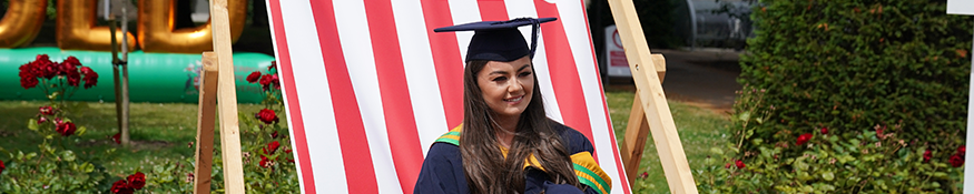 Graduate sat smiling on deck chair